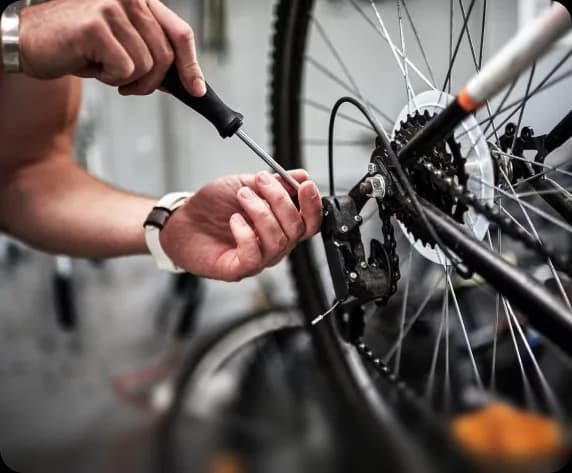 A mechanic adjusting a rear derailleur during a precision bike service.
